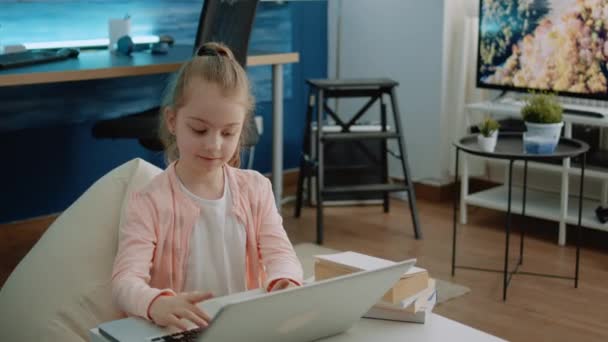 Ungt barn använder tangentbord på laptop för läxor och online-kurser — Stockvideo