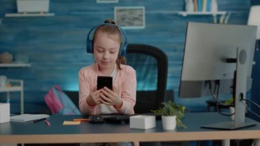 Öğrenci kız okul dersleri için akıllı telefondan video kullanıyor.