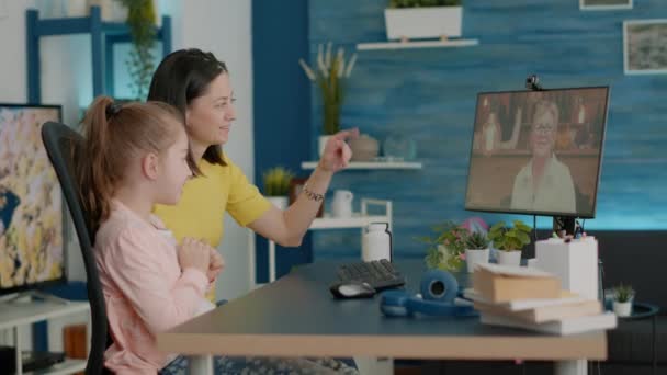 Madre e hija usando videollamada para chatear con la abuela — Vídeos de Stock