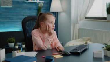 Sıkıcı öğrenci çevrimiçi ders için bilgisayar ekranına bakıyor