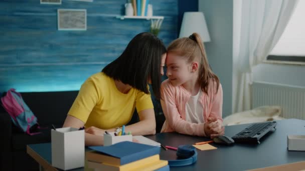 Liefdevolle moeder zit aan het bureau met dochter voor huiswerk — Stockvideo