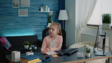 Anne küçük çocuğa uzaktan eğitim için ev ödevlerinde yardım ediyor.