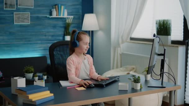 Child waving at video call webcam on computer for school work — Stock Video