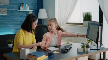 Anne ve kızı online ders için ödev yapıyor.