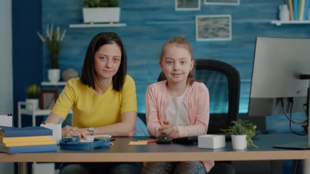 Портрет матері і дочки, що сидить за столом для домашнього завдання — стокове відео