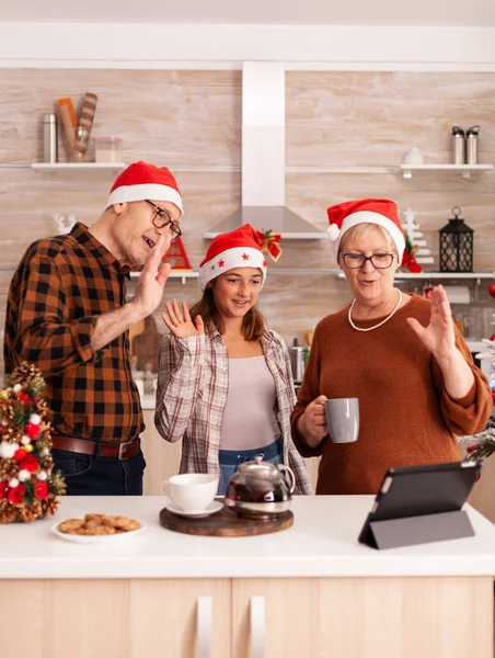 Glückliche Familie mit Weihnachtsmütze grüßt entlegene Eltern und genießt die Weihnachtsfeiertage — Stockfoto