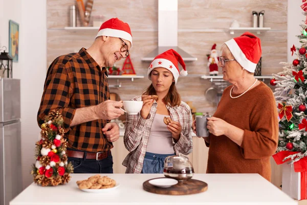 Lächelnde Familie feiert gemeinsam Weihnachten in weihnachtlich geschmückter Küche — Stockfoto