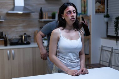 Sarhoş bir kocayla mutfakta oturan tacizci kadın.