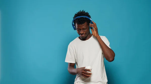Portrét radostného dospělého, který poslouchá hudbu na sluchátkách — Stock fotografie