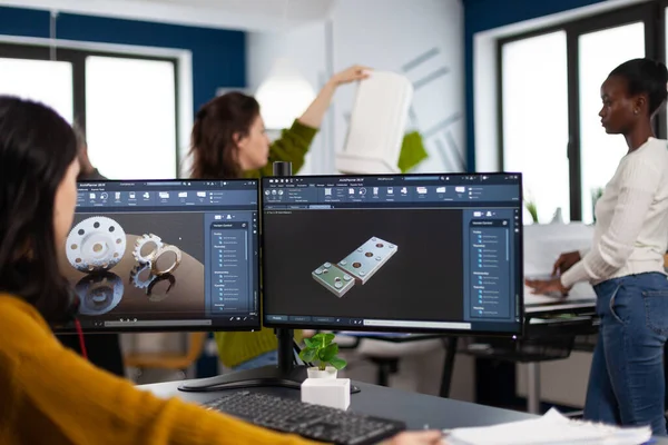 Ingeniera industrial que trabaja en PC con dos monitores, pantallas que muestran software CAD — Foto de Stock