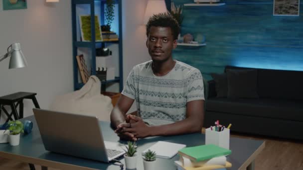 Hombre afroamericano sonriendo y trabajando en el portátil — Vídeos de Stock