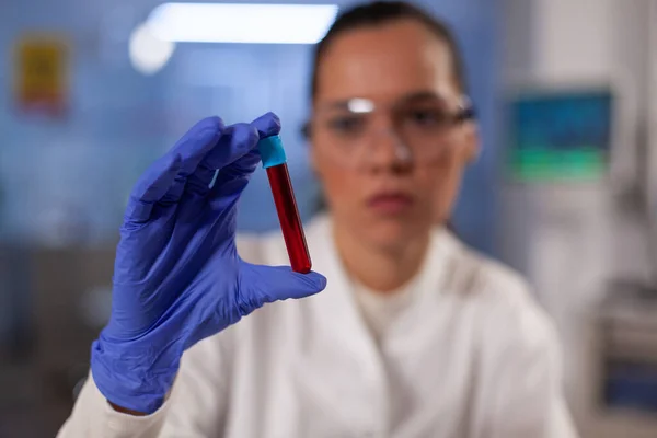 Научно-исследовательский врач держит пробирку с кровью — стоковое фото