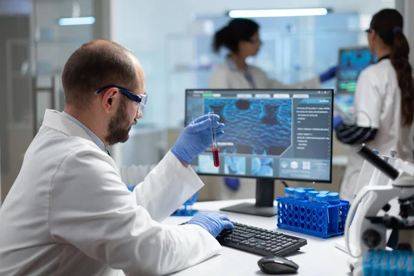 Biologist researcher holding blood test tube in hands analyzing virus expertise — Stock Photo, Image