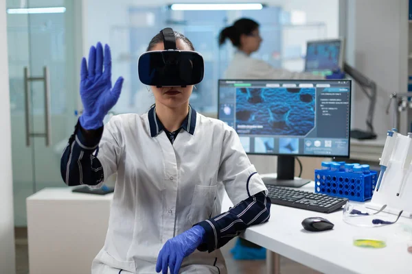 Chercheur biologiste portant un casque de réalité virtuelle examinant l'expérience de biochimie — Photo