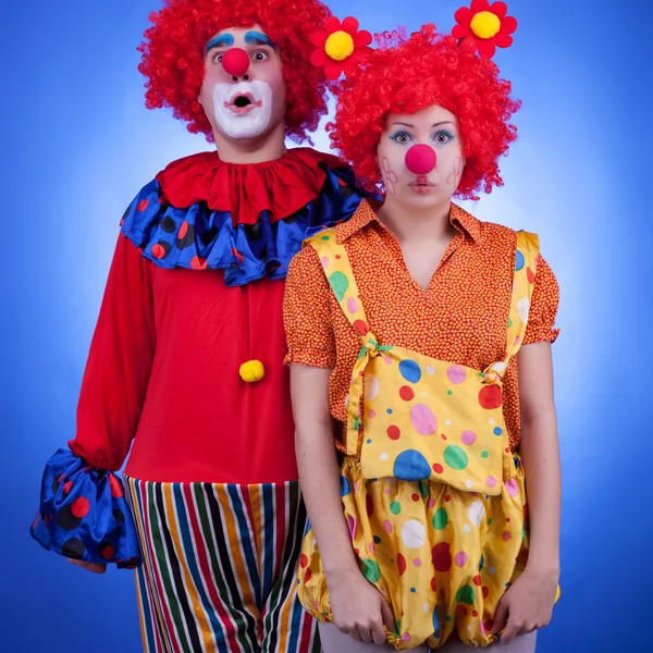 Clownspaar in Kostümen auf blauem Hintergrund — Stockfoto