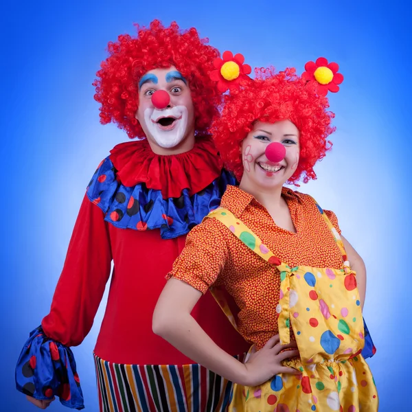 Couple de clowns en costumes sur fond bleu — Photo