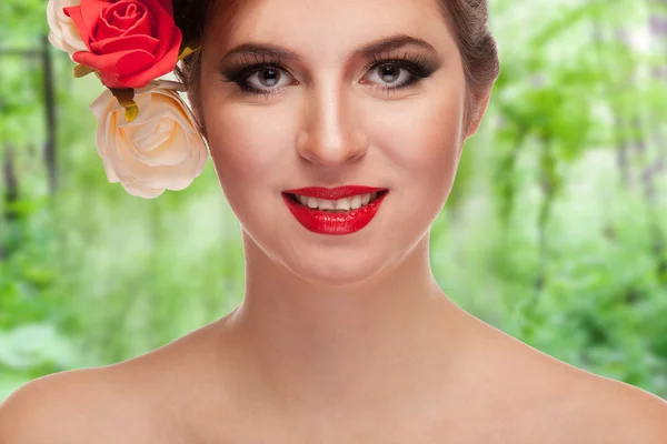 Mulher sorridente com flores na cabeça verde floresta fundo — Fotografia de Stock