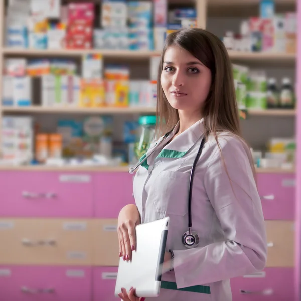 Joven farmacéutico con tableta digital en las manos —  Fotos de Stock