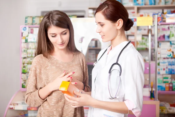 Woman doctor and client inside pharmacy — Stock Photo, Image