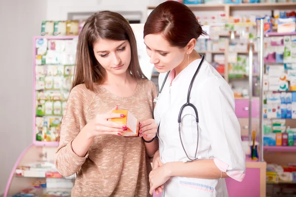 Mujer médico y cliente dentro de la farmacia — Foto de Stock