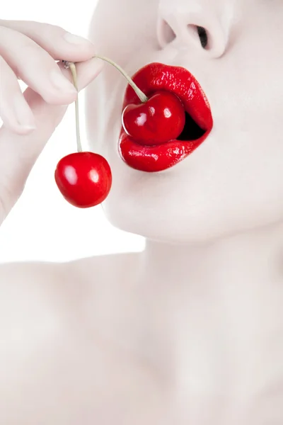 Boca con labios rojos mordiendo cereza — Foto de Stock