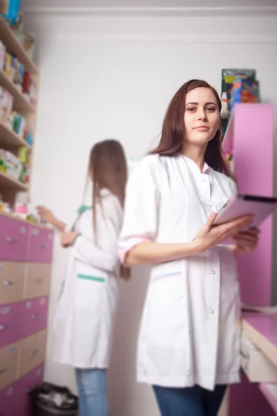 Farmacéutico en farmacia con tableta digital en las manos — Foto de Stock