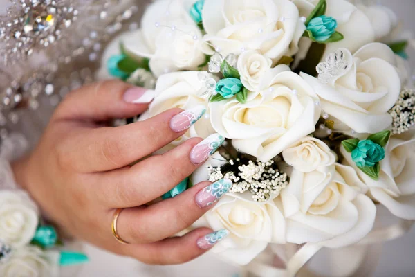 Bride with her nail done and the wedding flowers — Stock Photo, Image