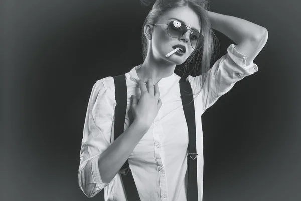 Woman with suspenders smoking sensual a cigarette — Stock Photo, Image