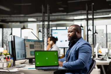 Siyahi genel müdür şirket başarısını laptopta yeşil ekranla garanti altına alıyor, iş dünyasındaki gelişim için beyin fırtınası çözümleri üretiyor. Verimli bir büyüme vizyonuna sahip girişimci.