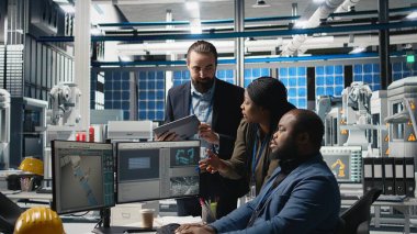 Yüksek teknolojili bir güneş paneli fabrikasında veri ve kontrol listelerini inceleyen bir grup profesyonel danışman, üretim sürecinin sürdürülebilir enerji ve yenilik standartlarını karşılamasını sağlıyor. Kamera A.