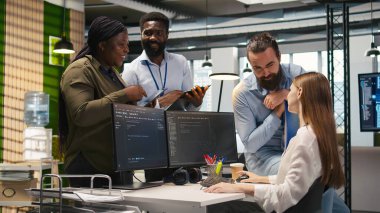 Yeni başlayan arkadaş ofiste arkadaş ediniyor, makine öğrenme teknolojisini kullanmayı öğreniyor. İş yerindeki neşeli genç kız iş arkadaşlarıyla sohbet ederken yapay zeka öngörüsü modelleri, kamera A kullanıyor.