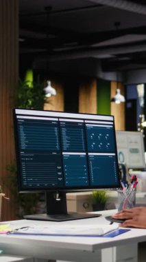 KPI ölçümlerini monitörde ve masaüstünde inceleyen Dikey Video Ofisi çalışanı, hedeflere ve başarıya ulaşmak için bir vizyon ve iş stratejisi oluşturmaktadır. Mesai sonrası profesyonel zihniyet