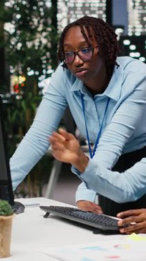 Dikey Video Afrikalı Amerikalı işçiler, ofis ortamında yenilik ve kalkınmayı hızlandırmak için cihazlar hakkındaki finansal görüşleri gözden geçirmek ve stratejiyi geliştirmek için dijital araçlar ve analizler kullanıyor.