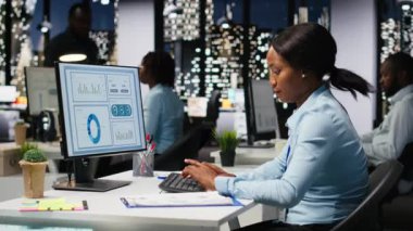 İş kadını hedeflere ulaşmak için proje verilerini düzeltme ve planlama, gece geç saatlerde karanlık ofiste görevleri çözme üzerine odaklandı. Bütçe ve hedefler hakkında idari öngörü. Kamera B.