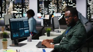 Yönetici, gece geç saatlerde bir bilgisayarda finansal veri bilgileriyle ilgilenerek, yenilikçi çözümler geliştiriyor ve proje hedeflerini şirket hedeflerine göre hizalıyor. Şirket ortamı. Kamera B.