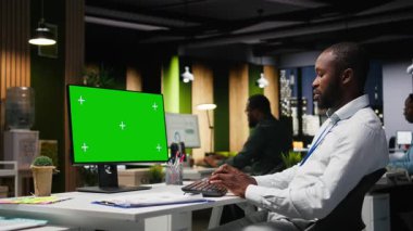 Genç siyahi işadamının verileri incelediği masaüstü bilgisayarında modelleme ekranı, analitik rapor yazma ve küresel genişleme ve iş yönetimi görevleri için çözümler bulma üzerinde çalışıyor. Kamera A.