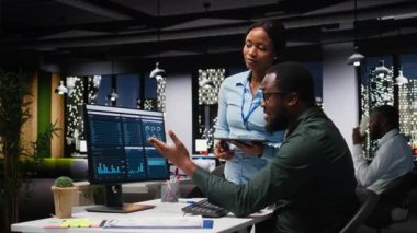 Profesyonel iş ekibi çevrimiçi grafikleri ve kaynak tahsisini analiz ediyor, performans raporlarını hazırlarken iş arkadaşları arasındaki ilişki ve sinerjiyi gösteriyor. Kamera A.