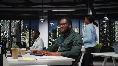 Siyahi erkek danışman, dijital araçlarla bilişim şirketinin gelişimine, analizlere ve iş yerindeki performans ölçümlerine odaklandı. Personel planlama çözümleri ve hedefleri hizalamak. Kamera A.