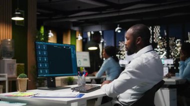 Erkek PC kullanıcısı, yapay zekanın evrimini vurgulamak için ofis saatlerinden sonra bilgisayardaki yapay zeka sohbet sistemiyle etkileşime geçiyor. Chatbot hizmetleri ve verimlilik için dijital araçlar. Kamera A.