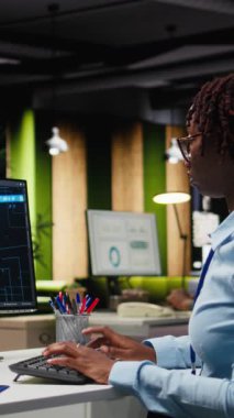 Bilgisayarda yapay zeka araçlarıyla KPI raporlarını inceleyen Dikey Video Profesyonel Analisti, makine öğrenimi için yapay zeka ağlarıyla çalışıyor. Yenilik ve optimizasyon vurgulanıyor