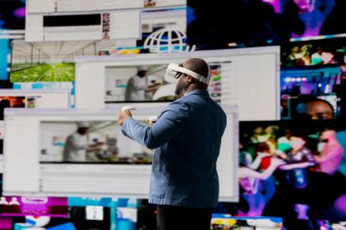 Siyah erkek uzman mobil beslemeler için yüksek teknoloji VR gözlükleri kullanıyor, dijital varlık, iletişim ve uygulama yoluyla etkileşim sergiliyor. Modern aygıtlar ve platformlar.