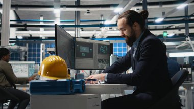 Güneş panelleri santralindeki bilgisayar görüşünü inceleyen profesyonel mühendis, üretim hattı ve kalkınma hedefleri için alternatif enerji sistemlerini güvence altına almak için bir teftiş yapıyor. Kamera A.