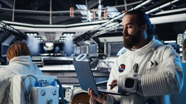 Gelişmiş teknoloji uzay araçlarındaki astronotlar rutin kontrol sırasında Kırmızı Gezegen 'in uçuş günlüğünü güncellemek için birlikte çalışıyorlar. Sistem tanılarına bakan Yörünge İstasyonu mürettebatı meslektaşları