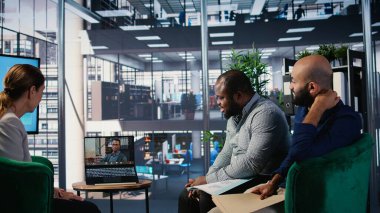 Çok kültürlü bir grup, yönetim kurulundaki bir video konferansında çevrimiçi planlama ve hedef odaklı liderlik tartışmaları yoluyla iş dünyasının başarısına odaklanıyor. Kamera A.