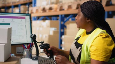 Barkodları yöneten personel, çevrimiçi alışveriş siparişleri, nakliye etiketli ürünler ve kolay teslimat için ayrıntıları tarama görevlerini aksatmaktadır. Memnuniyet merkezi çalışanı. Kamera B.