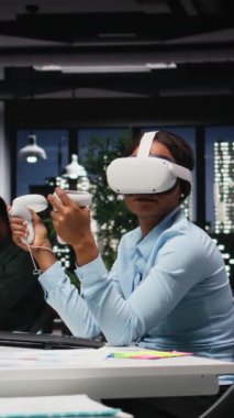 Saatler sonra yapay zeka ile VR kulaklık kullanan dikey video kadın ofis çalışanı, görevlerin tamamlanması ve öngörü tahminleri için sanal gerçeklikle sıkı çalışıyor. 3B simülasyon