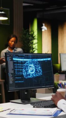 Dikey Video Siyah çalışma arkadaşları aylık veri raporları için yapay zeka analiz platformunu, nöral ağ algoritmalarını ve iş verimliliği için otomasyonu gözden geçiriyorlar. IT şirketinin temsilcisi