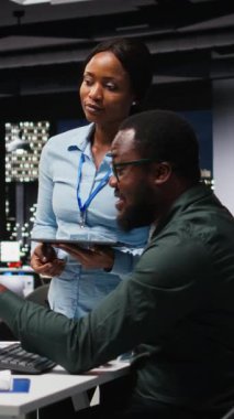 Vertical Video Professional iş ekibi çevrimiçi grafikleri ve kaynak tahsisini analiz ediyor, performans raporlarını hazırlarken iş arkadaşları arasındaki ilişki ve sinerjiyi gösteriyor. Kamera A.