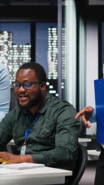 Profesyonel çalışma alanındaki veri içgörülerini gözden geçiren Dikey Video İki siyah işçi, strateji planlaması ve hedeflere ulaşmak için performans ölçüm analizi ile iş çözümleri geliştirme