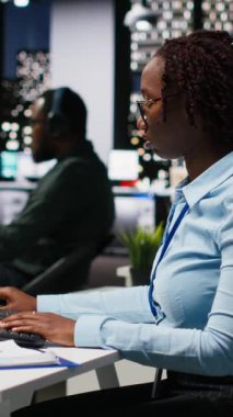 Dikey Afrikalı Amerikalı kadın KPI ölçümlerini PC monitöründe yapay zeka ile inceleyerek yapay zeka ile derin öğrenim için yapay zeka ağları ile çalışıyor. Yenilik ve optimizasyon vurgulanıyor